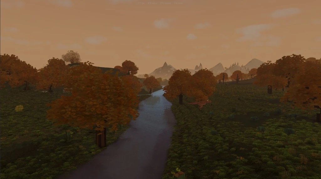 A river cutting through autumn grassland toward distant mountains